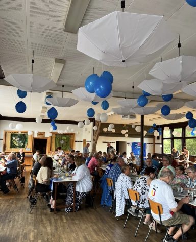 Eingedeckte Tische in einem festlich dekorierten Restaurant mit blauen Ballons.